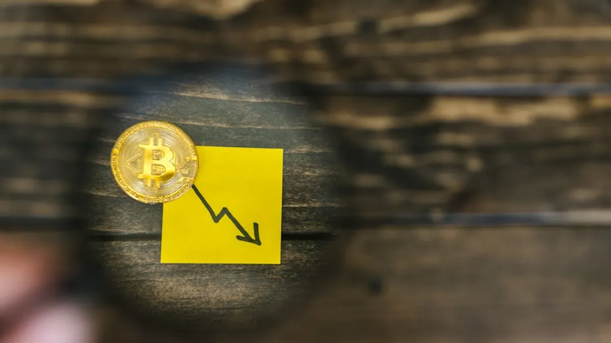 A gold Bitcoin and downward trend arrow symbolizing cryptocurrency market decline.