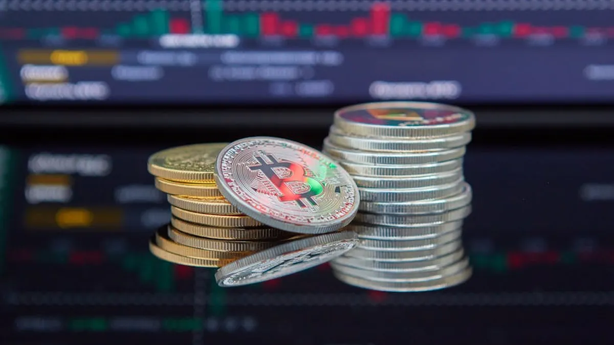 Close-up of cryptocurrency coins with a market graph background.