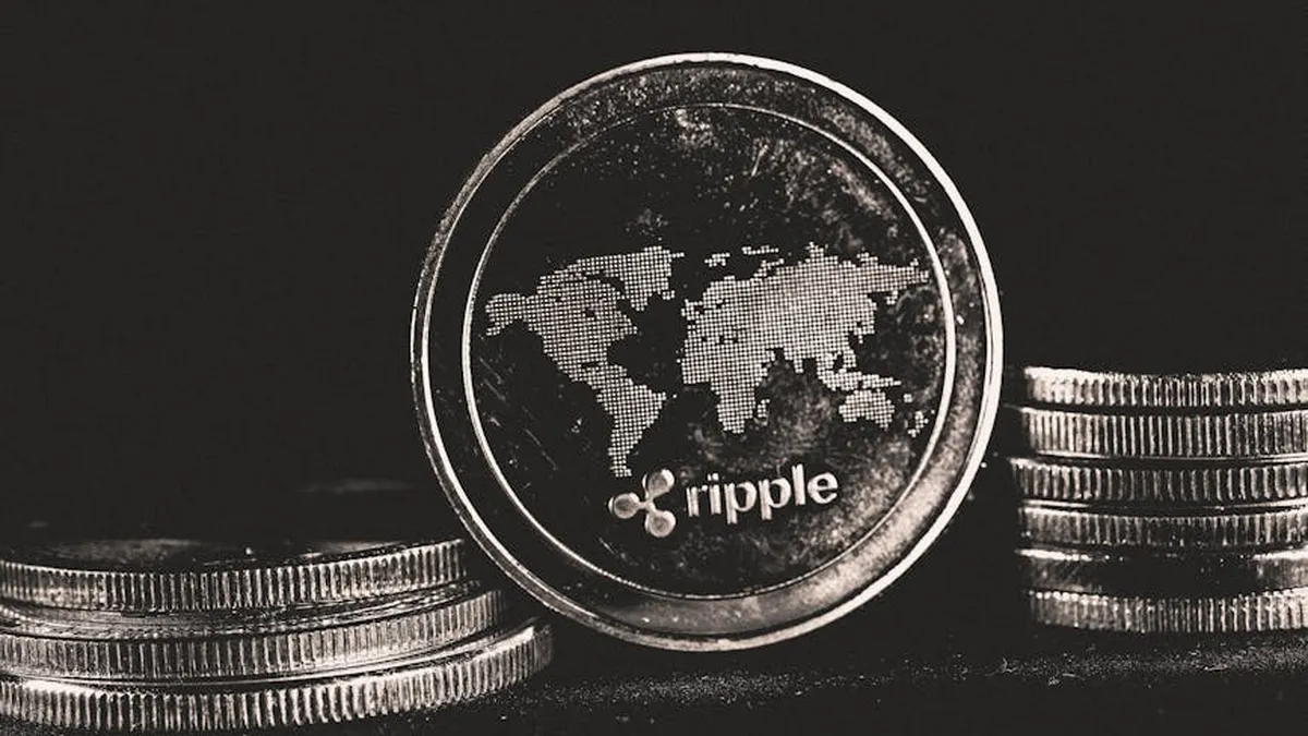 A detailed shot of a Ripple coin with a world map design on a black background.