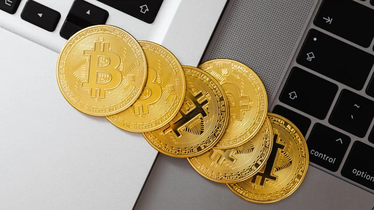 Golden Bitcoin coins spread across laptop keyboards showcasing digital currency and finance.