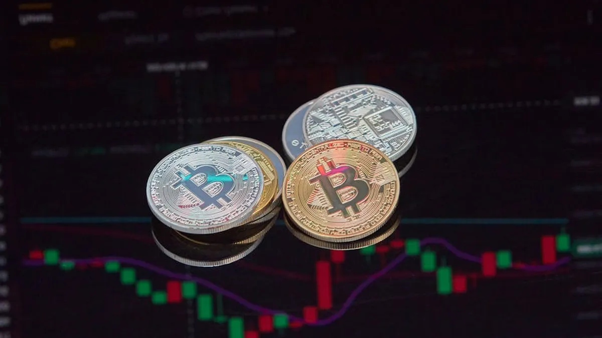 Close-up view of Bitcoin coins on a stock market chart background representing cryptocurrency trading.