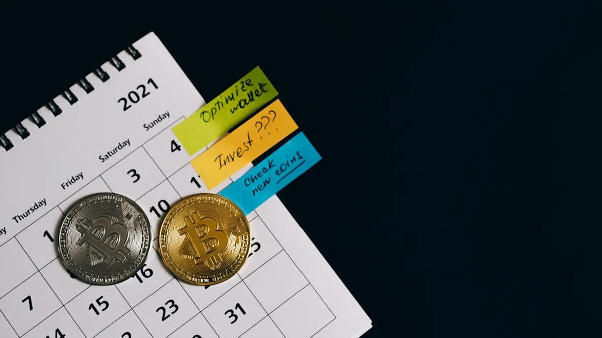 Close-up of Bitcoins on a calendar highlighting investment plans with sticky notes.