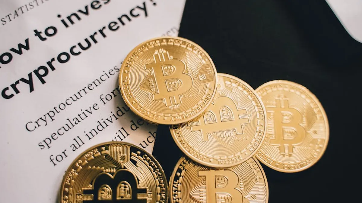 Close-up of Bitcoin coins alongside an investment guide in cryptocurrency.