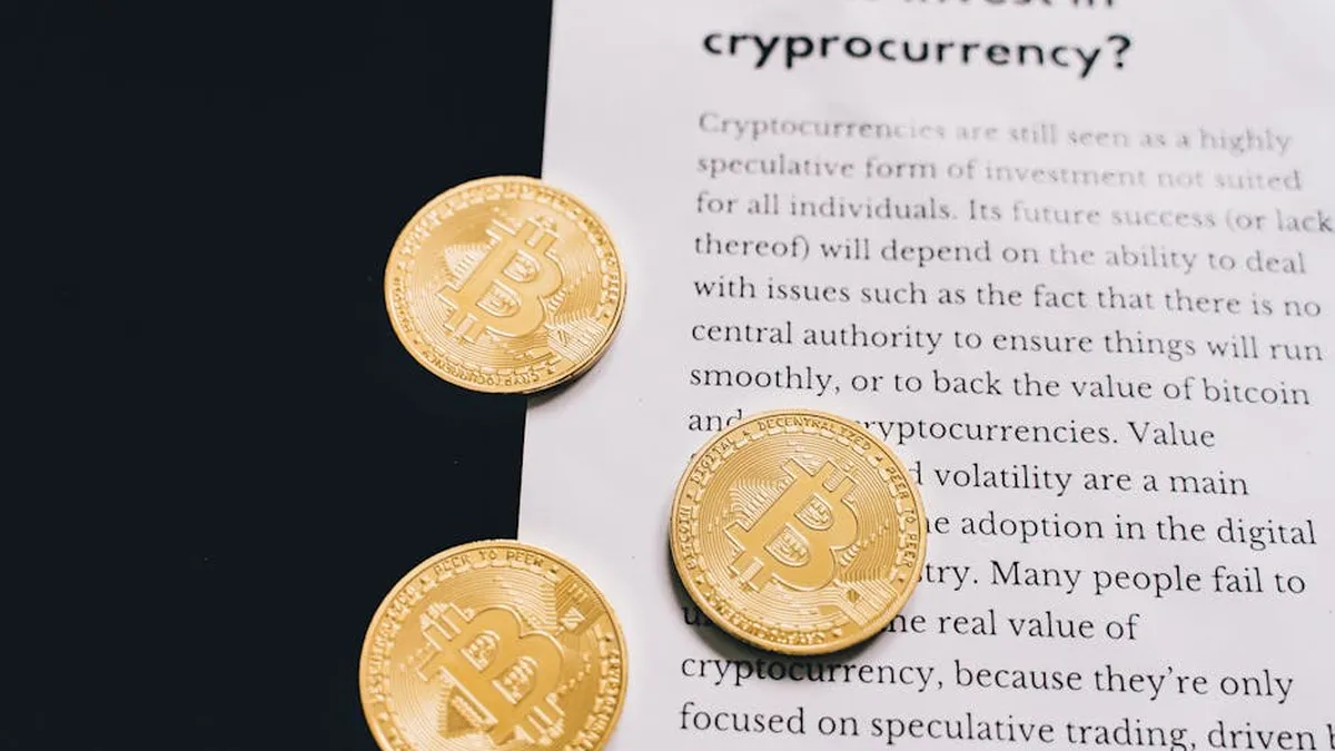 Gold Bitcoin coins on top of a cryptocurrency investment guide. High-quality finance and cryptocurrency image.