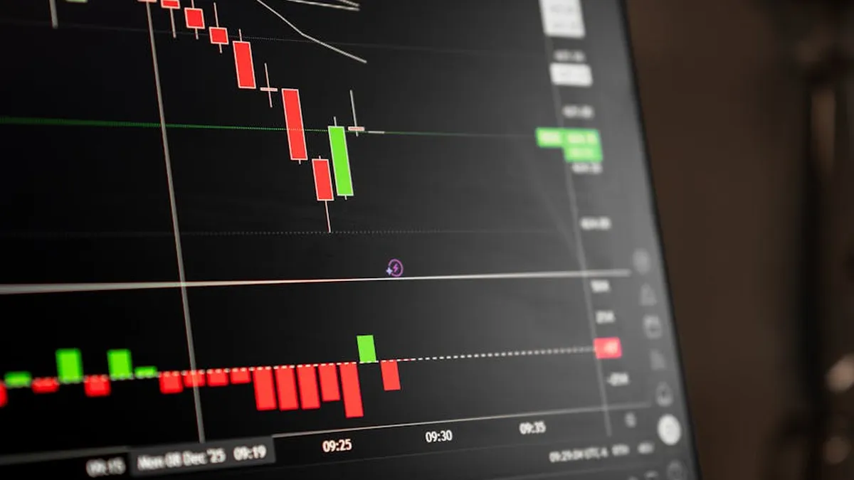 A close-up of a digital screen showing stock market candlestick chart data.