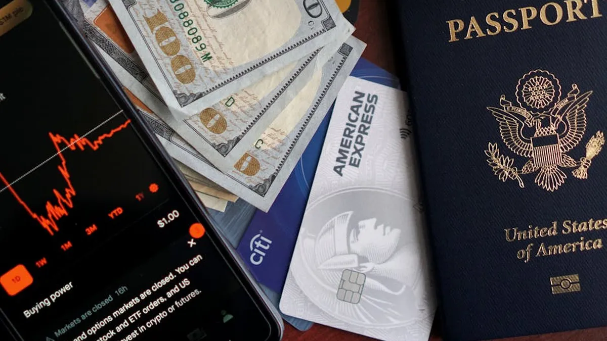 Stock trading concepts with passport, credit cards, cash, and smartphone app image.