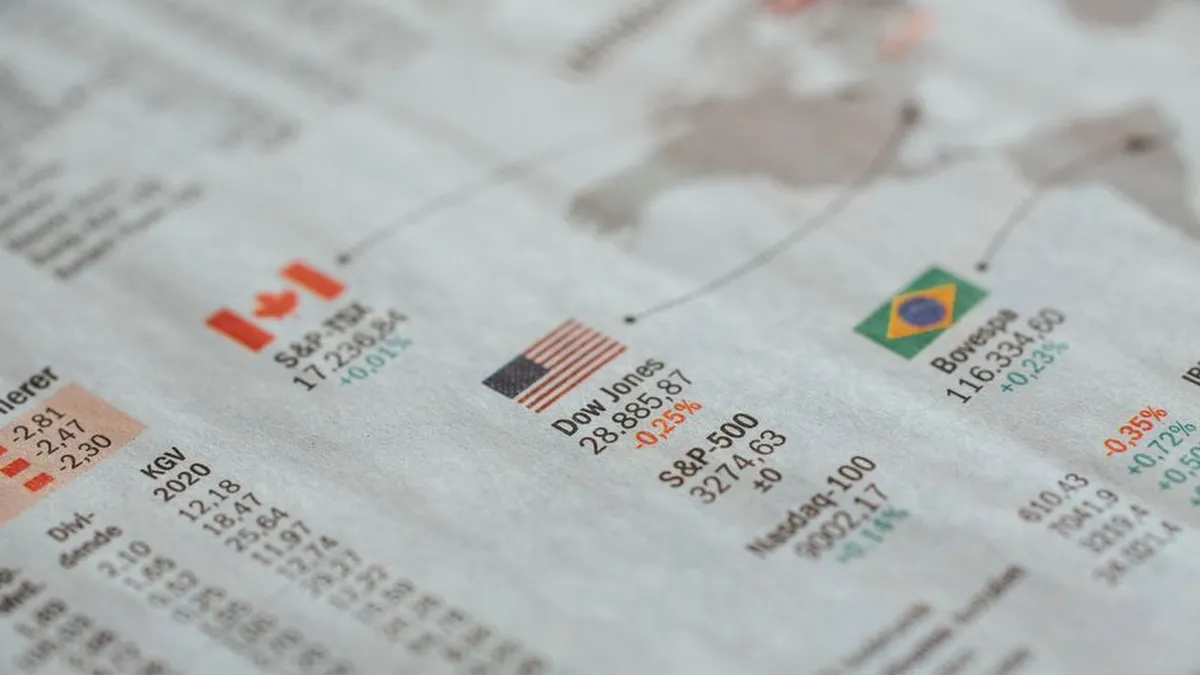 Detailed close-up of a newspaper displaying global financial market statistics and country flags.