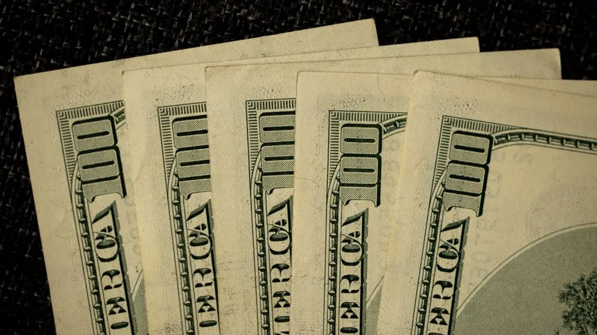 Detailed image of multiple one hundred dollar bills arranged in a stack.