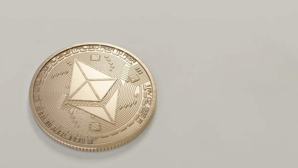 A golden Ethereum coin placed on a neutral light background, symbolizing digital currency.