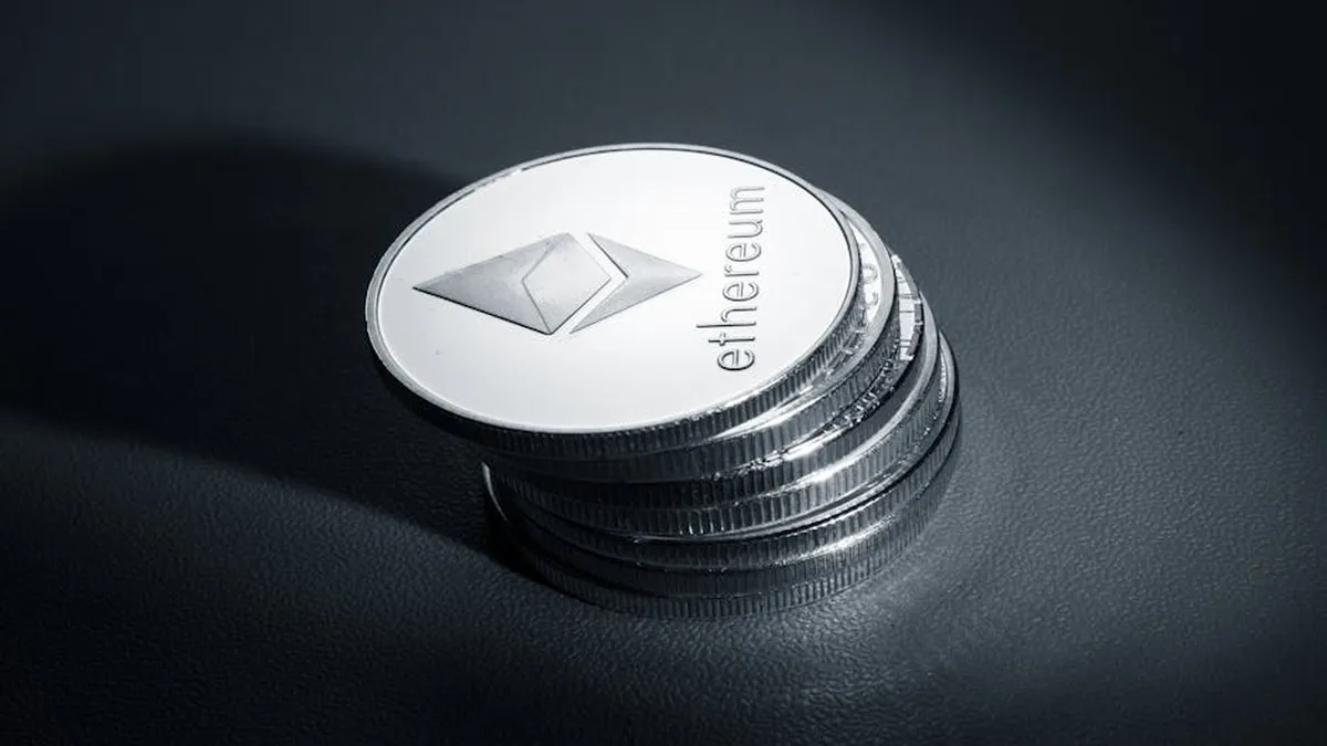 Close-up of stacked Ethereum coins on a dark textured surface, symbolizing modern cryptocurrency.