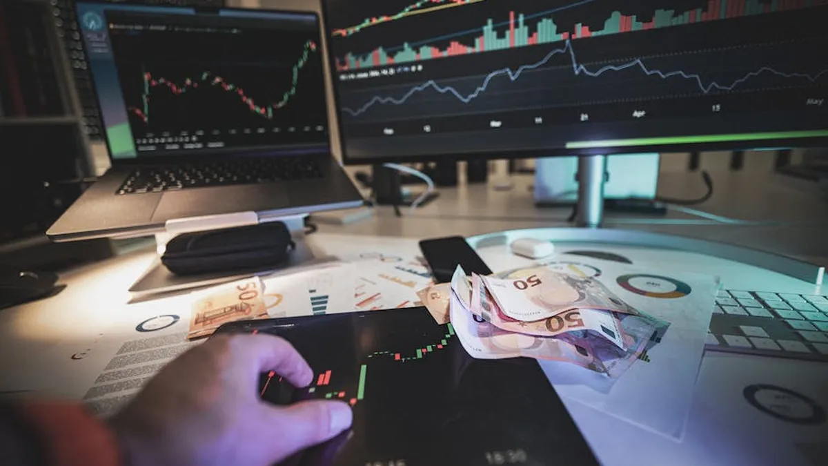 A modern trading desk with screens showing market charts and euro notes, capturing a trading atmosphere.