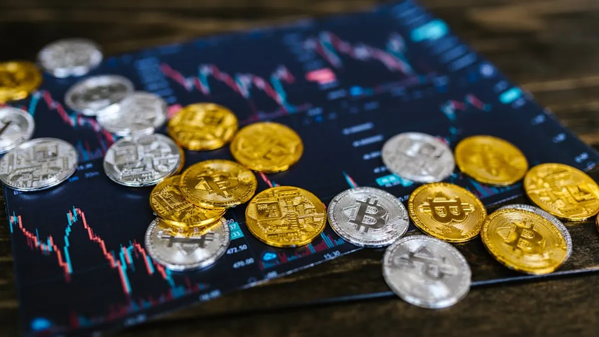 Gold and silver Bitcoin coins on financial graph, symbolizing cryptocurrency trading and digital currency wealth.