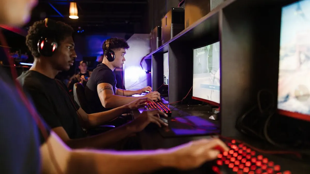 Young adults gaming at a modern LAN center with advanced PCs, showcasing intense gaming focus.
