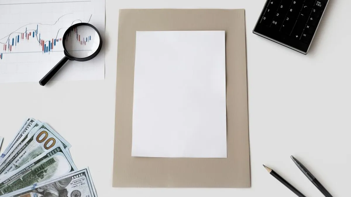Flat lay of financial tools and blank paper for planning or mockup.