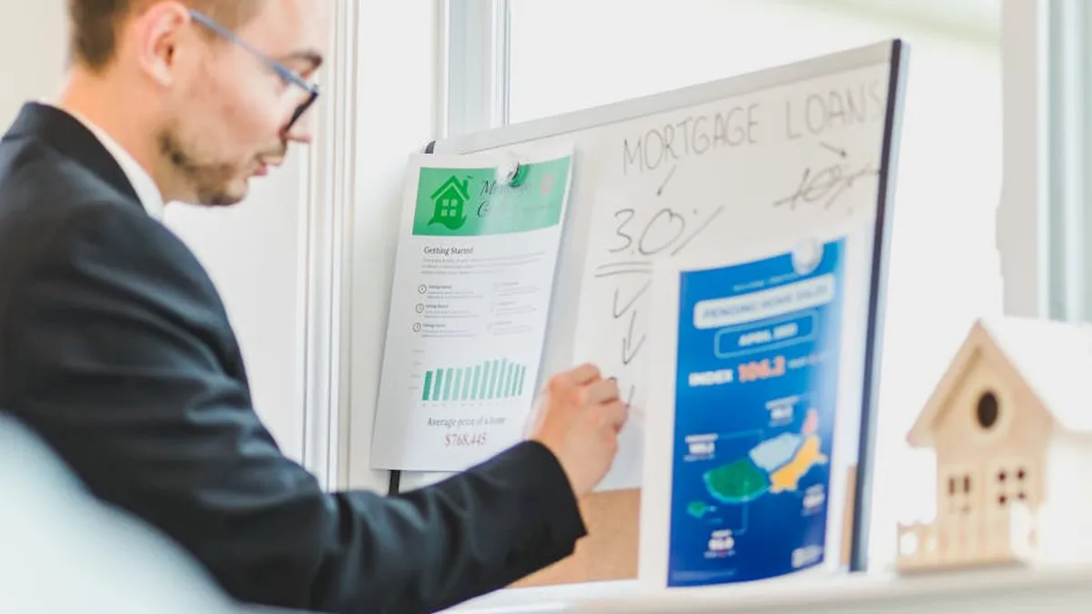 Real estate agent analyzing mortgage loan details on a whiteboard in an office setting.
