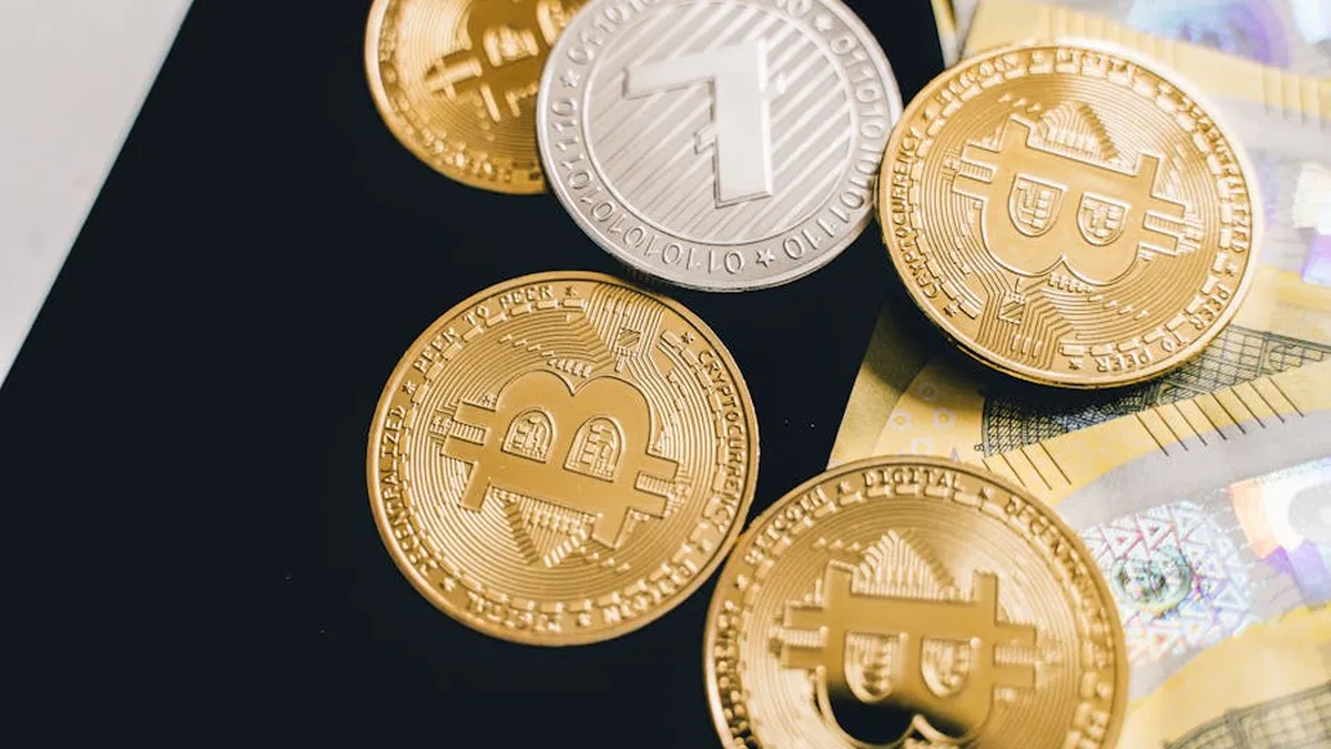 Detailed view of Bitcoin and cryptocurrency coins on euro banknotes, symbolizing digital currency investment.