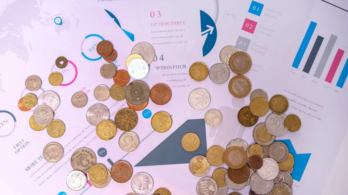 Image of various coins on financial documents with graphs and charts.