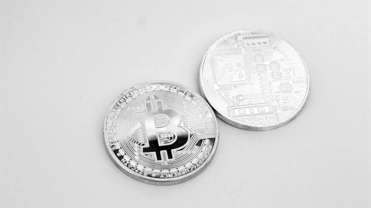 Close-up of two silver Bitcoin coins showcasing digital currency and modern finance.
