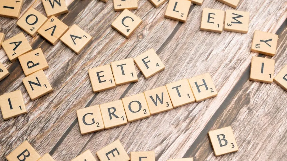 Wooden tiles spelling ETF growth on a wooden surface, symbolizing investment strategy