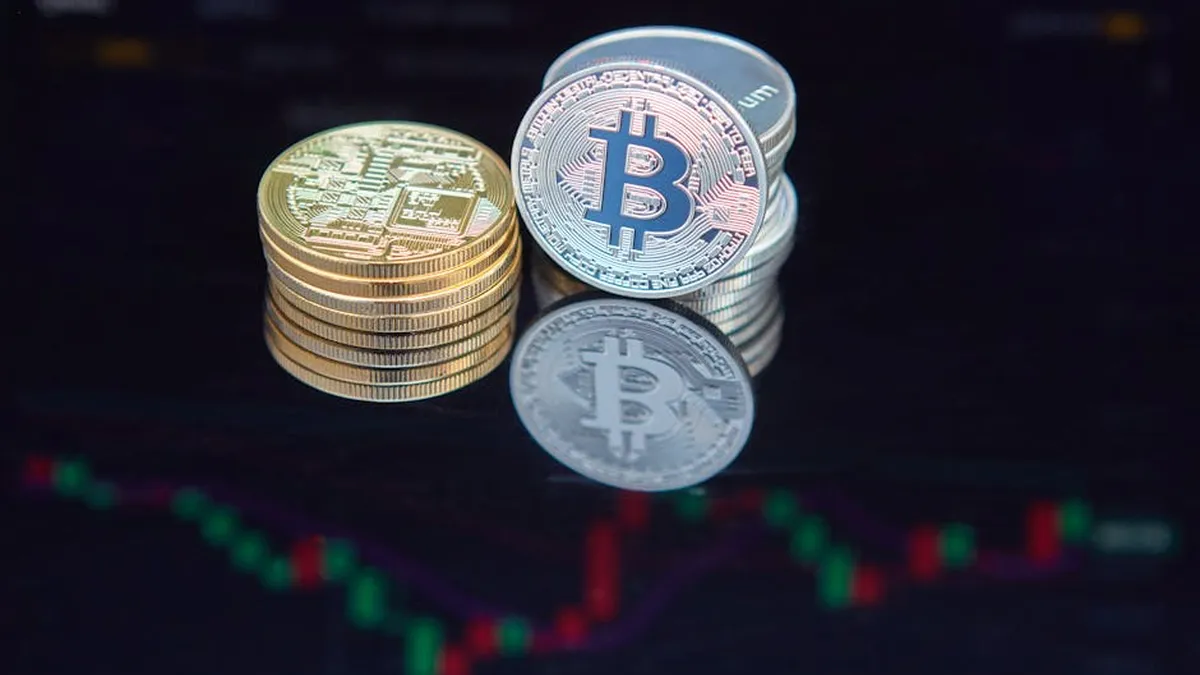 Close-up of bitcoin coins reflecting on a screen with financial market data, highlighting digital currency trend.