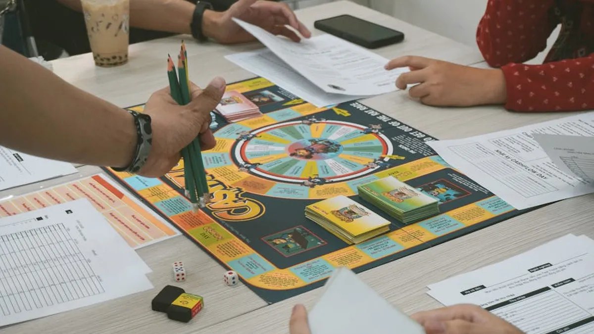 A group of adults playing the Cashflow board game, concentrating on financial planning.