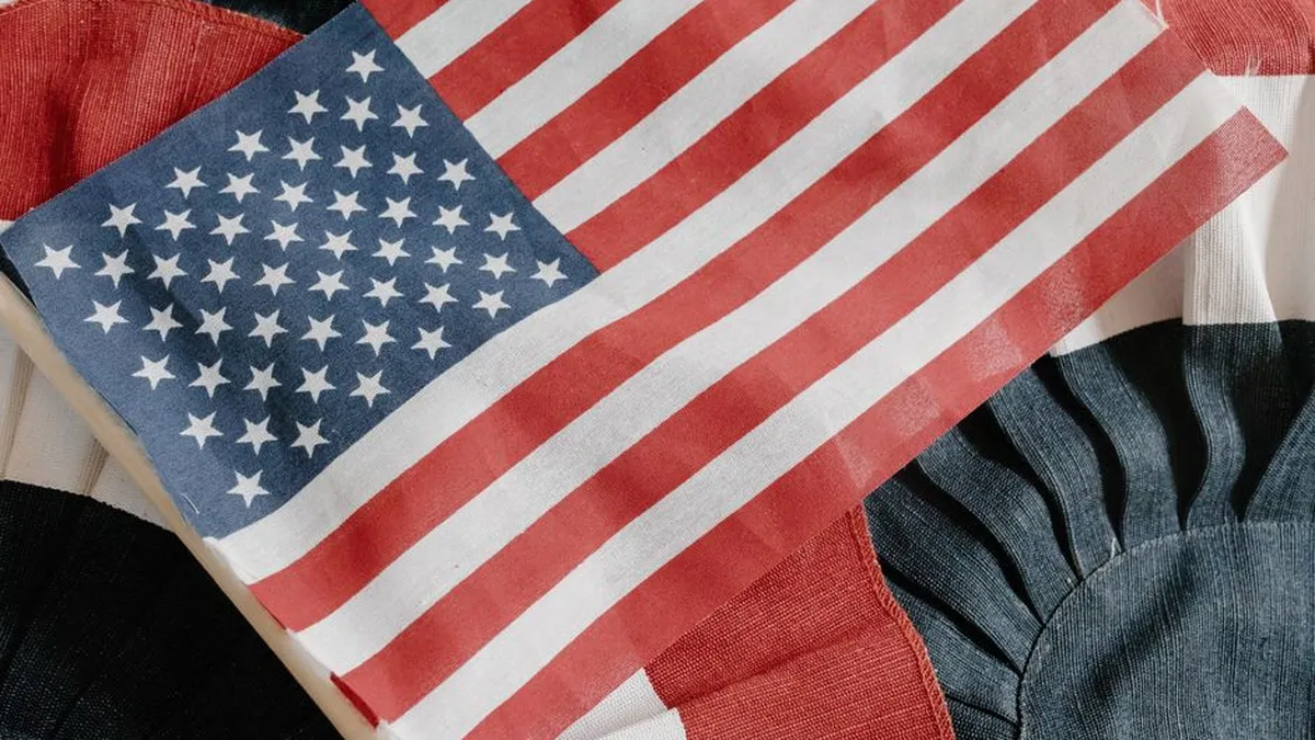 Close-up of the American flag on a textured fabric backdrop, symbolizing patriotism and national pride.
