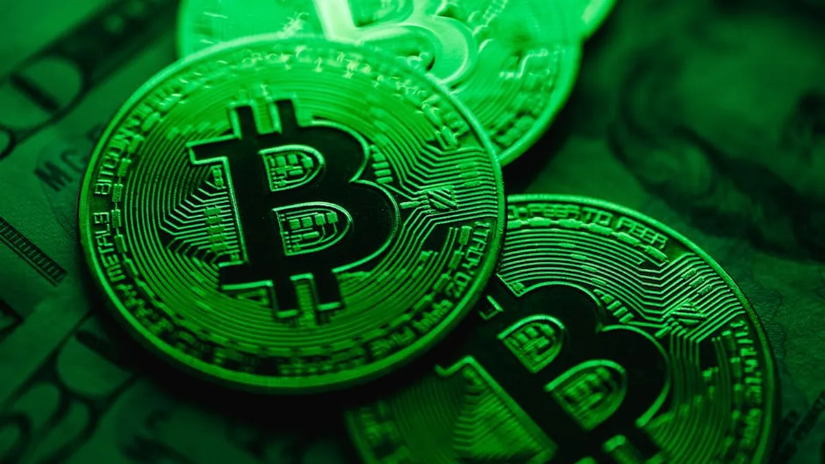 Close-up image of shiny Bitcoin coins with a digital green light effect, symbolizing blockchain technology.