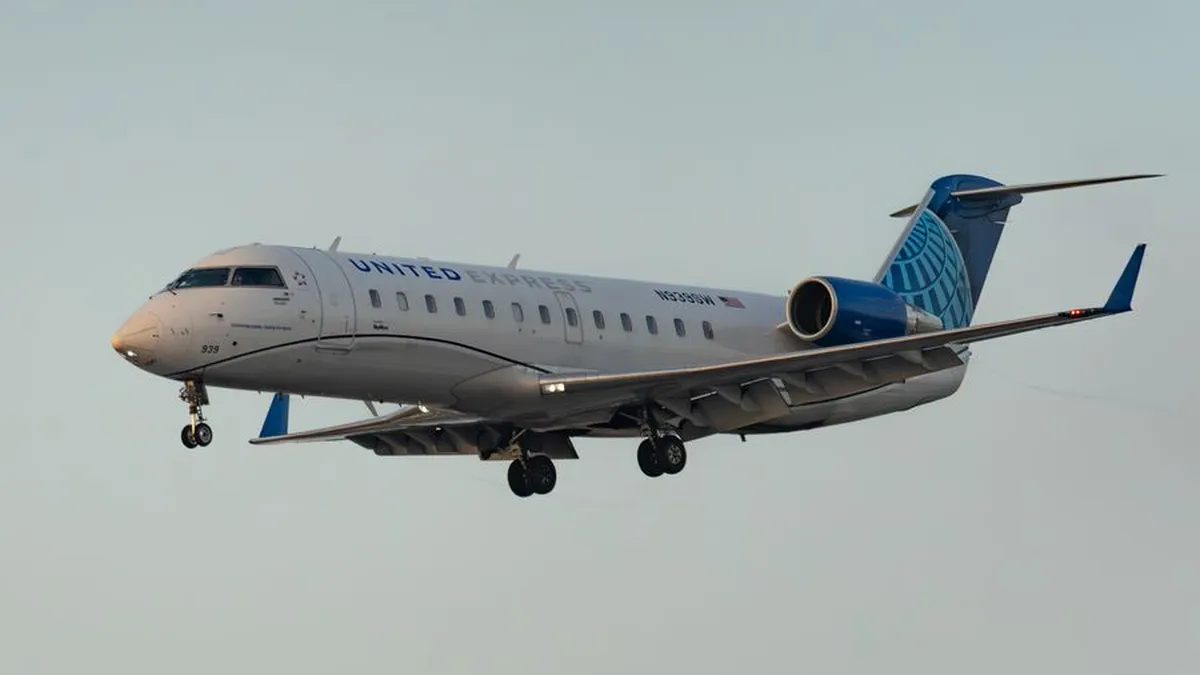 United Express jet captured flying against a clear sky, showcasing aviation in action.
