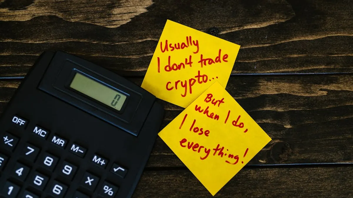 Funny sticky notes about cryptocurrency trading with calculator on wooden table.