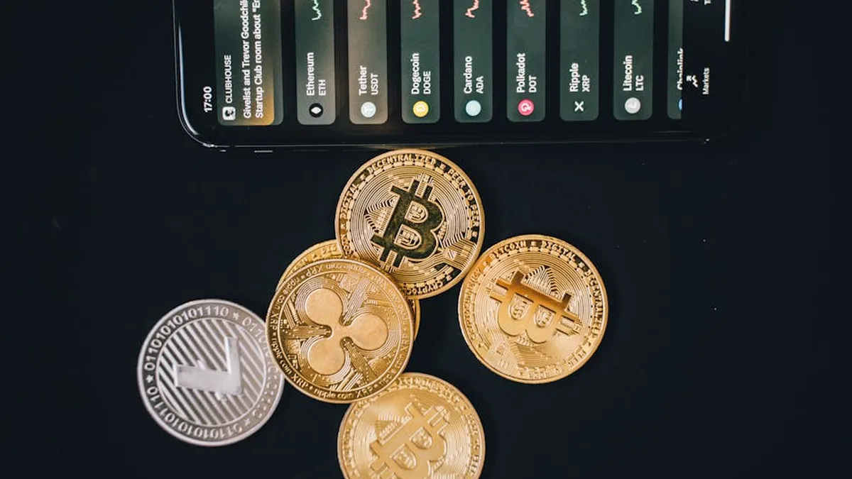 Close-up of various cryptocurrencies and a smartphone showing market trends.